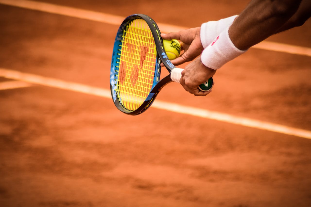 classes-03 Close-up of a tennis player preparing to serve on a clay court in Montevideo.